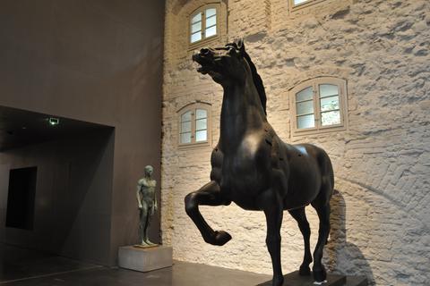 Eines der beiden "Schreitenden Pferde" des NS-Bildhauers Josef Thorak in der Ausstellung in Berlin. Im Hintergrund: Arno Brekers Statue "Zehnkämpfer", die Hitler seinem Reichssportminister schenkte.