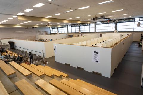 In den ehemaligen Hallen der Martin-Buber-Schule wurden verschiedene Bereiche mit weißen Wänden abgetrennt. Foto: Vollformat/Volker Dziemballa