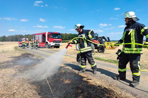 Eine ausgedorrte Grasböschung brennt am Samstag nahe Ober-Breidenbach. Die Feuerwehr löscht.  Foto: Pilipp Weitzel 