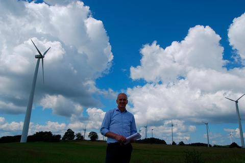 Ulrichsteins Bürgermeister Edwin Schneider vor den Windrädern bei Helpershain. Hier sollen sich in Zukunft sehr viel weniger, aber sehr viel höhere Windkraftanlagen drehen. Foto: Hack 
