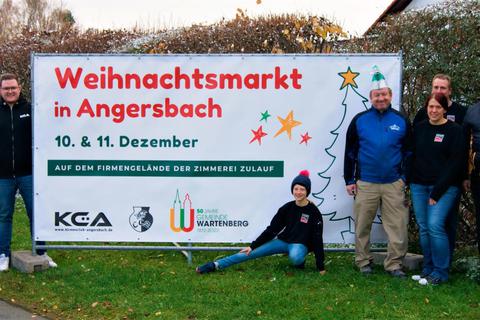 Sie hoffen auf zahlreiche Besucher: Aktive des Zeppe, Mitglieder der Kirmesclubs, die Familie Zulauf und Oliver Raatz von der Klima-Technik Eichenauer mit dem Plakat für den Angersbacher Weihnachtsmarkt. © Gohlke