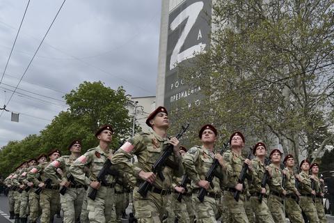 Russische Soldaten marschieren im ukrainischen Sewastopol. Im Hintergrund wird der Buchstabe Z zelebriert. Er ist zum Symbol des russischen Militärs geworden.