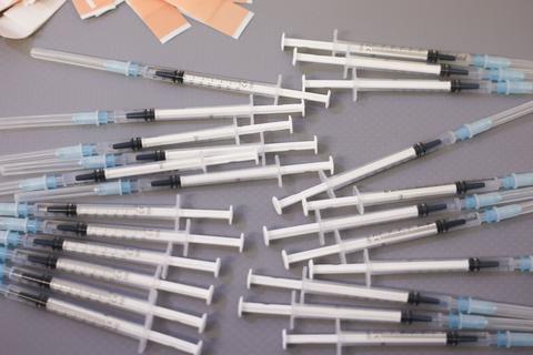 Spritzen und Pflaster für eine Impfung liegen auf einem Tablett. Symbolfoto: dpa