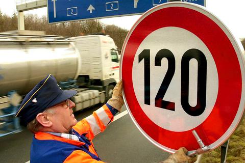Die Autobahnmeisterei montiert ein Schild für Tempolimit 120.