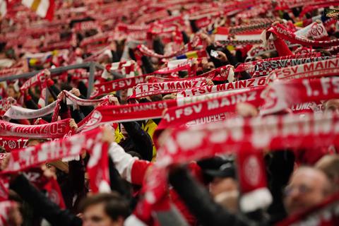 Fans des FSV Mainz 05 halten in der Mewa Arena ihre Fanschals hoch.