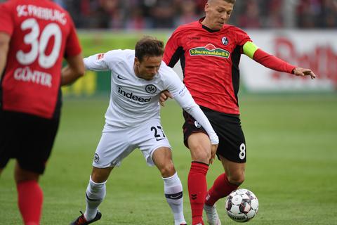 Torschütze Nicolai Müller (l.) von Frankfurt und Mike Frantz (r.) von Freiburg kämpfen um den Ball. Foto: dpa