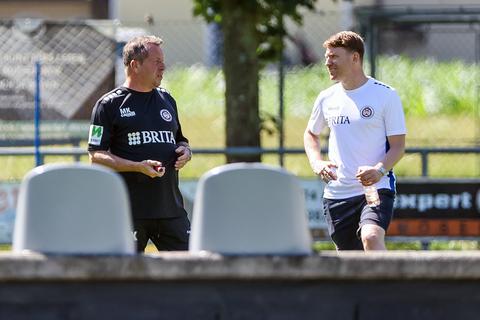 Der Sportliche Leiter Paul Fernie (rechts) am Rande des Trainings im Austausch mit Trainer Markus Kauczinski.